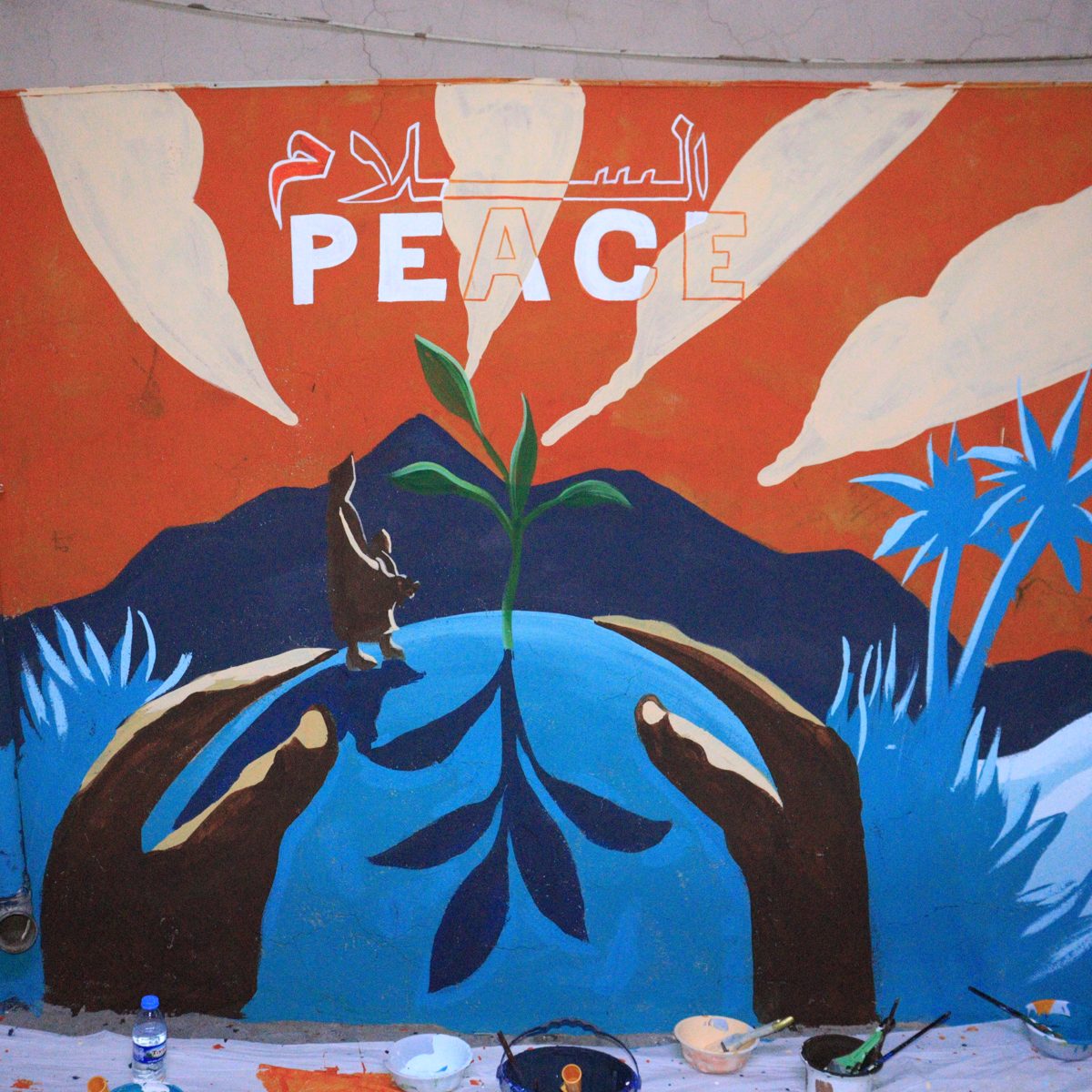 “Peace” mural by young artists: hands holding a globe with a seedling growing from it
