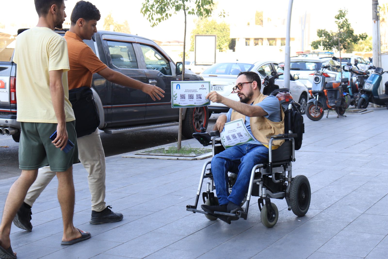 A volunteer in a wheelchair handing out flyers during an accessibility campaign