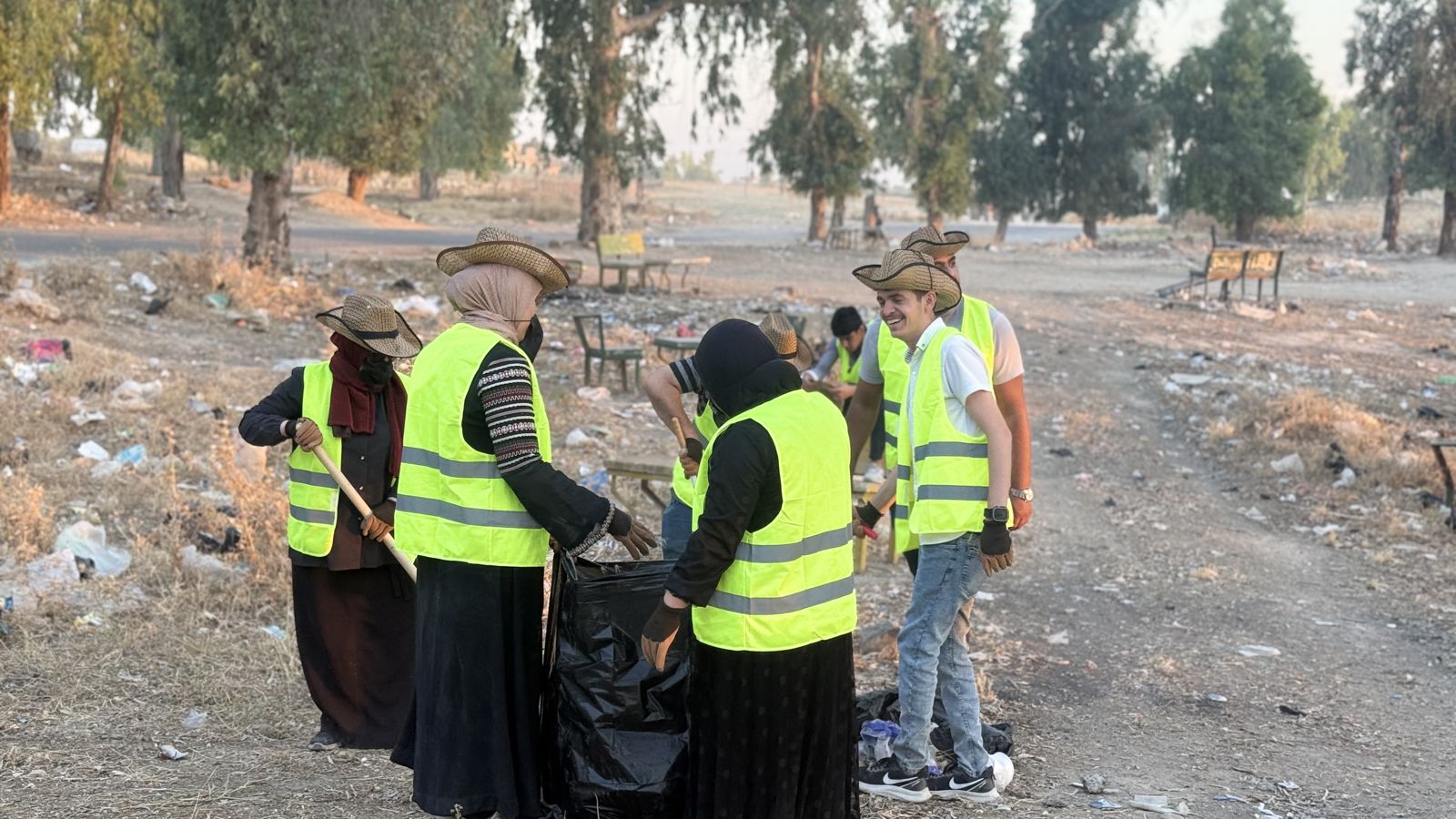 Community volunteers in high-visibility vests during a park clean-up